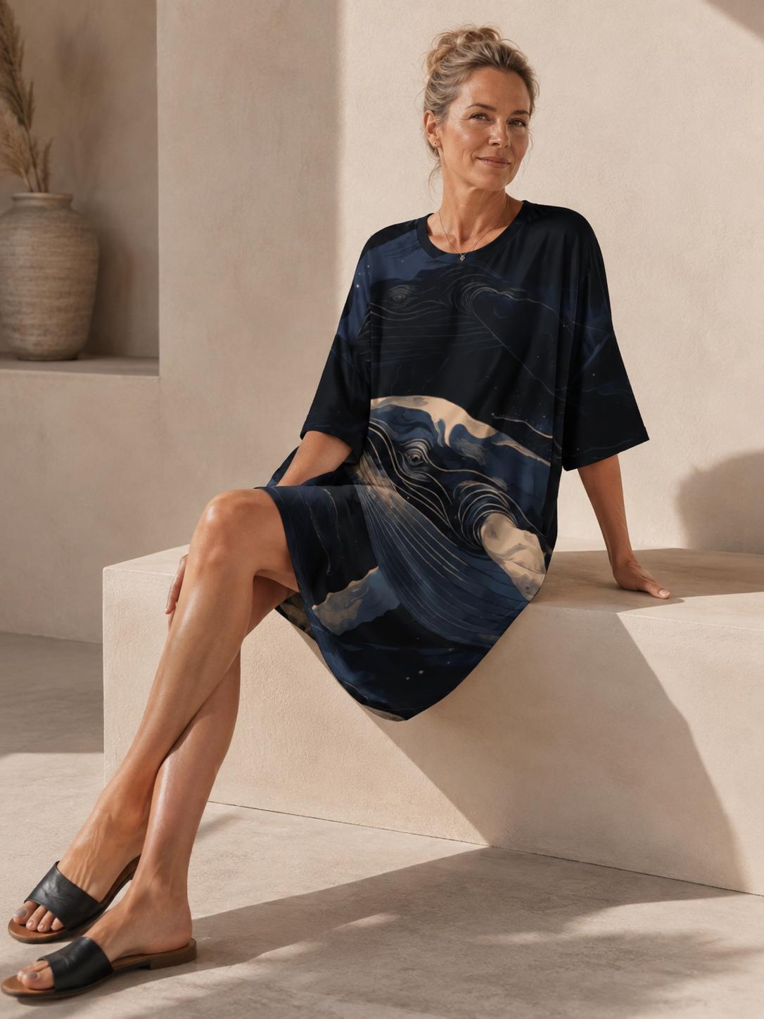 May include: A loose-fitting, short-sleeved dress featuring a dark navy blue and black base with a prominent graphic print of a whale swimming through swirling, abstract ocean waves in shades of cream, light blue, and deep indigo.